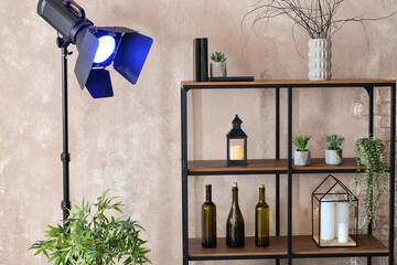 Modern shelf unit with glowing lamp near light wall