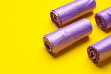 Rolls of garbage bags on color background