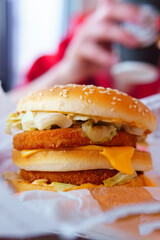 burger with chicken on the table of a fast food restaurant. close-up selective focus. Vertical photo