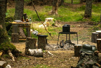 A metal kettle warms up on a campfire while hiking, camping in the woods