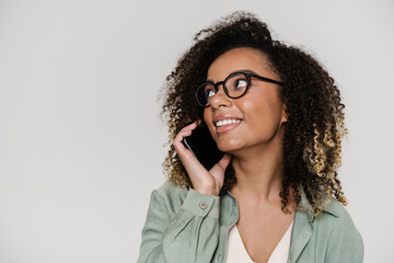 The smiling woman talking on the phone and looking to the side in the studio