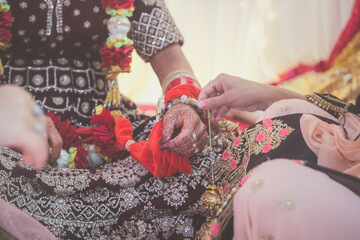Indian Punjabi wedding ceremony doli and pani varna, ritual items and hands close up