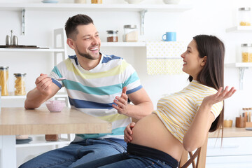 Beautiful pregnant couple in kitchen