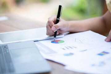 Image of document with charts on background of male and female working , business concept