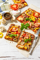 Home made baking. Detroit-Style Pizza. Large rectangular Pepperoni pizza with tomatoes, salami and cheese on a rustic wooden table. Copy space.