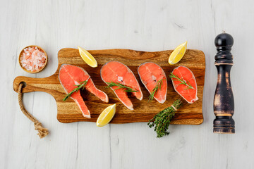 Overhead view of raw trout steaks on wooden cutting board