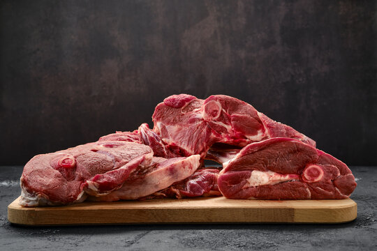 Assortment of raw lamb meat on wooden tray