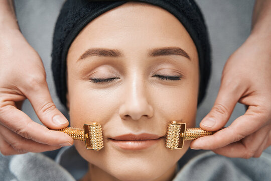 Client Getting A Facial Massage With Acupressure Metal Roller Massagers