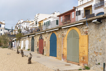 View of colored doors of fishermen's huts in front of the sand of the beach in CALELLA DE PALAFRUGELL