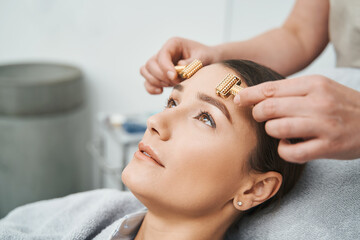 Patient skin being massaged with acupressure metal roller massagers