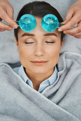Serene woman patient having her forehead massaged with ice globes - obrazy, fototapety, plakaty