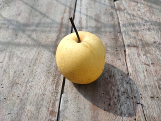 Pear fruits and her shadows on the wood surface in the sunshine