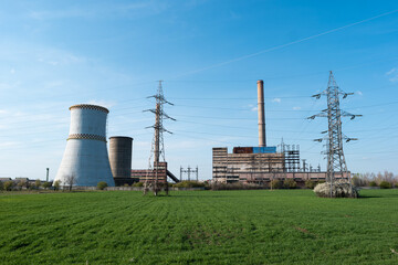 Fototapeta na wymiar Disaffected coal-fired power plant station in the field clear day blue sky steaming furnace