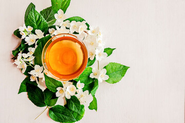 Glass Cup of green Jasmine fragrant, medicinal tea. Alternative medicine. White wooden background. The view from the top. Copy space.