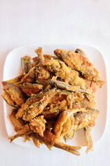 River fried battered fish perch on a white plate on a white background. Home cooking. Top view. Vertical.