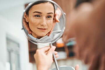 Concentrated lady viewing her reflection in the presence of her cosmetician