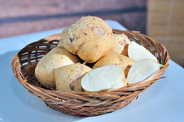 Jicama in a bamboo basket with a few slices