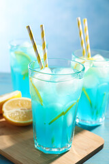 Delicious refreshing cocktail with ice on wooden table