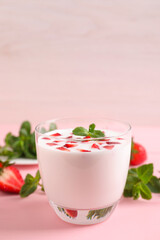 Delicious drink with strawberries on pink table