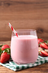 Delicious drink with strawberries on wooden table
