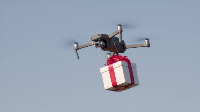 small drone flying cross country carrying giftbox to its destination