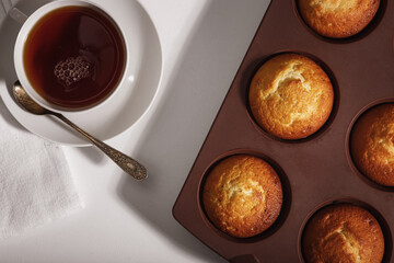 The concept of home baking. Fresh delicious muffins on the table.