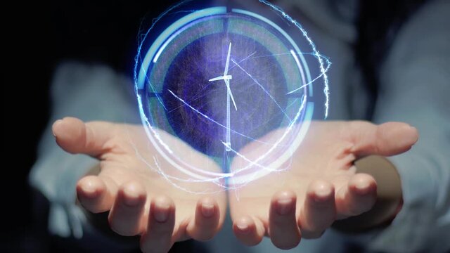 Female hands show a round conceptual hologram with modern eolic wind mill. Unrecognizable woman in ashen white on a black background with future holographic technology