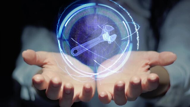 Female hands show a round conceptual hologram with adjustable wrench hand tool. Unrecognizable woman in ashen white on a black background with future holographic technology