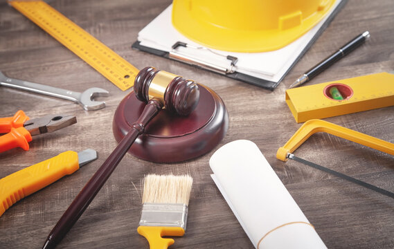 Judge gavel, safety helmet and working tools. Construction Law