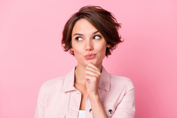 Photo portrait of thoughtful woman looking at blank space isolated on pastel pink colored background