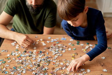 Top view of solving jigsaw puzzle on the table