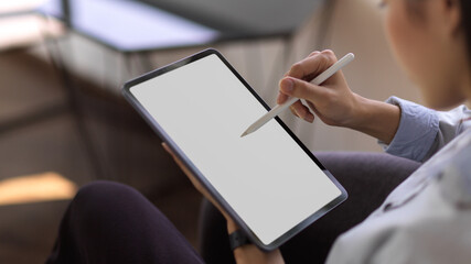 Businesswoman using digital tablet with mock up screen while relaxing in cafeteria