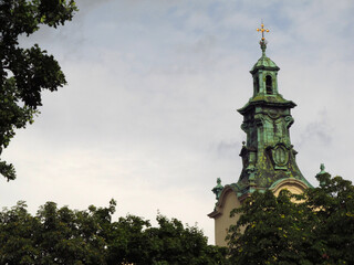 Widok na wieżę katedry Wniebowzięcia Najświętszej Maryi Panny we Lwowie na tle liści, Ukraina © vofchok