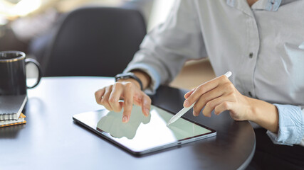 Close up view of young female using mock up blank screen digital tablet