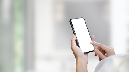 Cropped shot of woman holding mock up smartphone with blurred office background