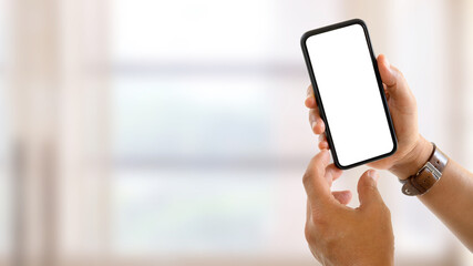 Close up view of male hands showing mock up smartphone screen to camera in blurred background