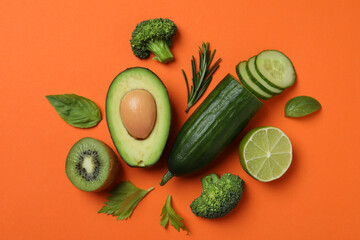 Group of fresh green vegetables on orange background