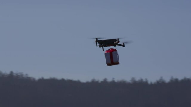 small drone flying cross country carrying giftbox to its destination