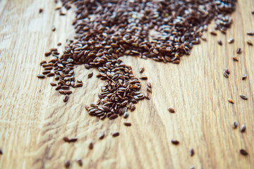 Scattered flax seeds on wooden background. Healthy eating concept. Side view
