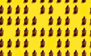 Empty brown medicine glass bottle of cosmetic liquid on bright yellow background. Concept of the organic, zero waste cosmetics. Pattern seamless