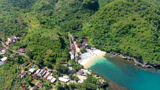 Tiny white sand Gesing beach by steep cliffs and remote village on Java coast