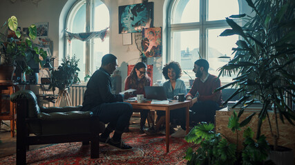 Team of Young People Talking on a Meeting in Modern Creative Office. Diverse Group of Professionals Brainstorm, Share Data on Tablet Computer, Creating Social Media Marketing Content. 