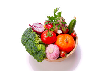 A set of fresh vegetables in a wooden bowl . On a white isolated background. Healthy eating.