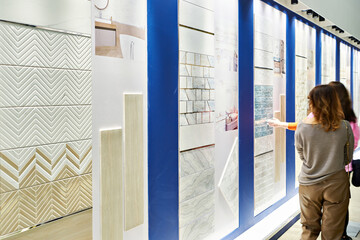 Women choose samples of tiles for bathroom in store