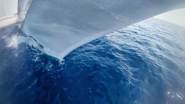 White boat sails on the sea. Prow and blue water.