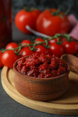 Bowl with tomato paste on dark wooden table with ingredients