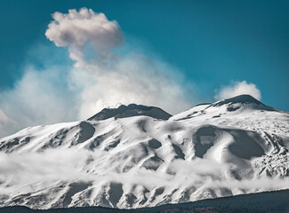 Ash coming from the  snow covered peaks of Mount Etna - the highest active volcano in Europe 