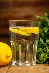 Water with sliced lemon on wooden background