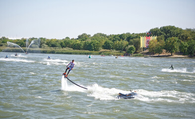  The athlete flies with a water jet from the side of a water motorcycle in front of the audience at...