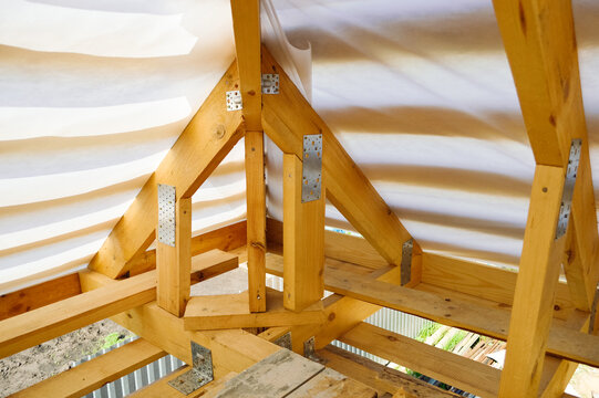 Close-up - Fasteners On Wooden Rafters During Roof Construction, Waterproofing Film On Top